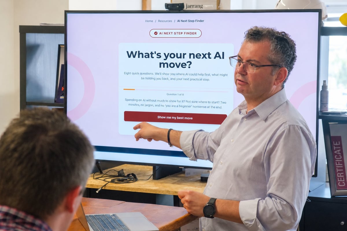 Man in gray shirt presenting to audience with display screen showing Whats your next AI move? presentation slide
